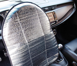 Un parasol que cubre el volante en el interior de un coche.