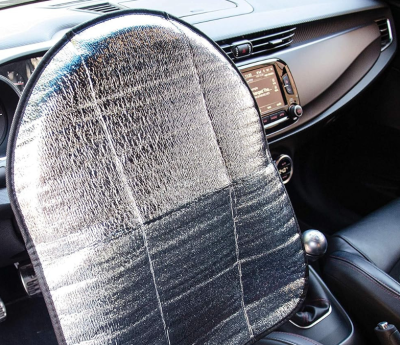 Un parasol que cubre el volante en el interior de un coche.