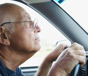 Señor mayor conduciendo