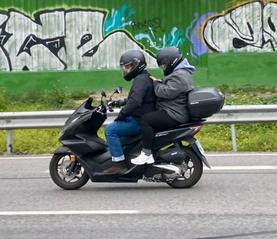 Pasajero de una moto utilizando el móvil