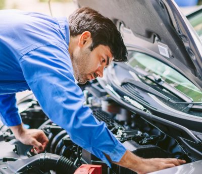 Joven mirando motor coche
