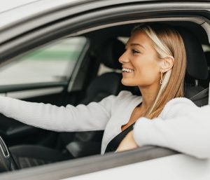 Mujer conduciendo codo ventanilla